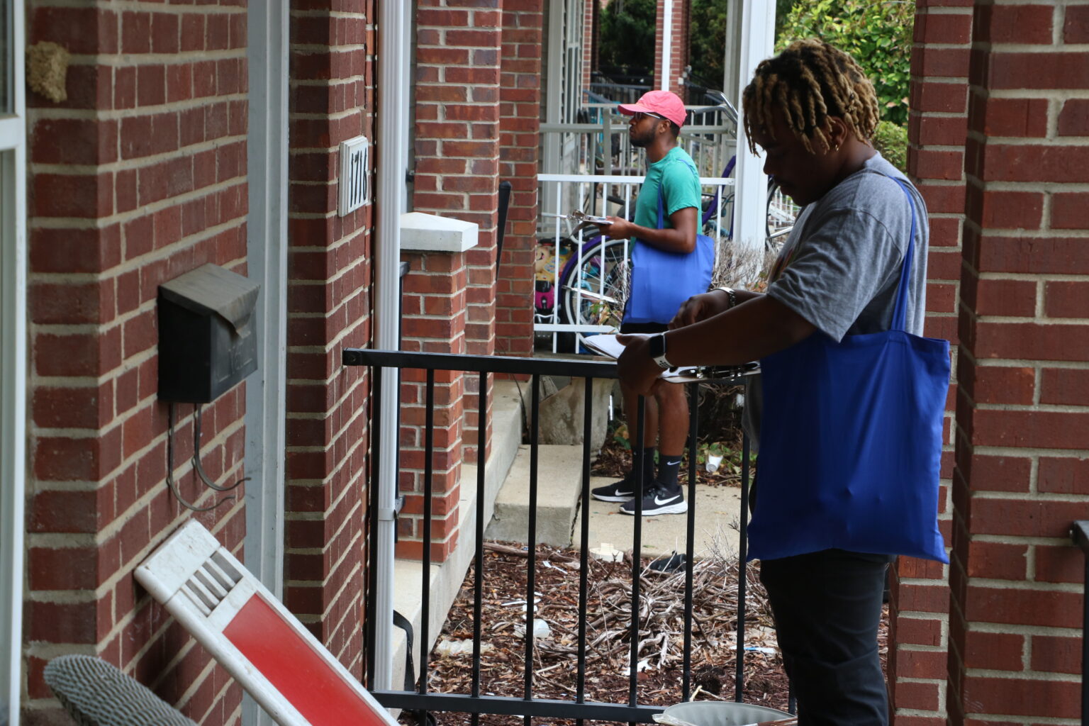 Two canvassers stand in front of doorways getting the word out about LG&E and KU's power proposal.