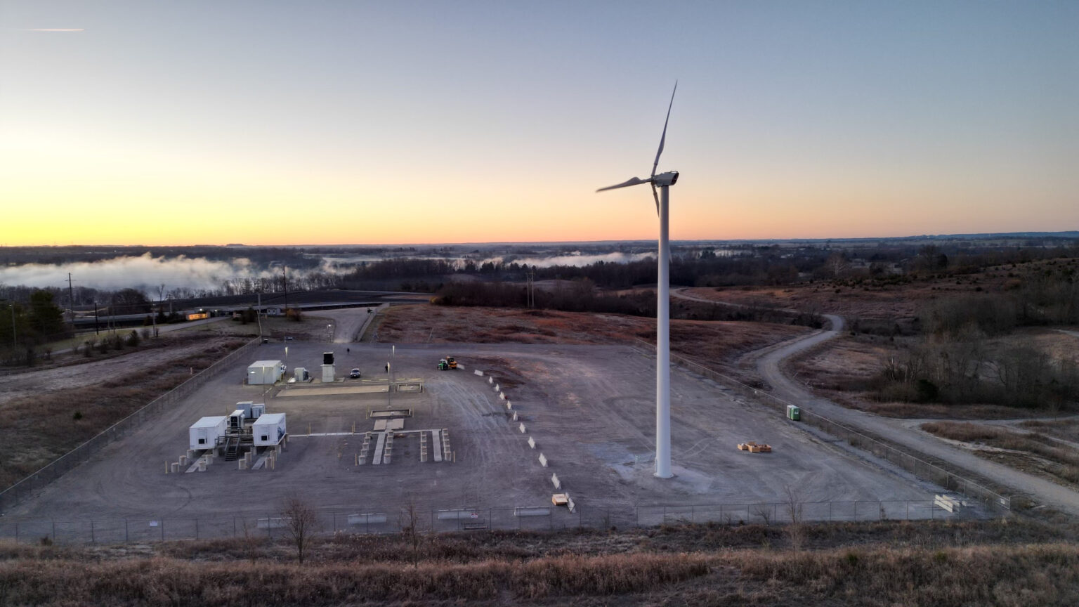 A wind turbine stands tall during the evening.